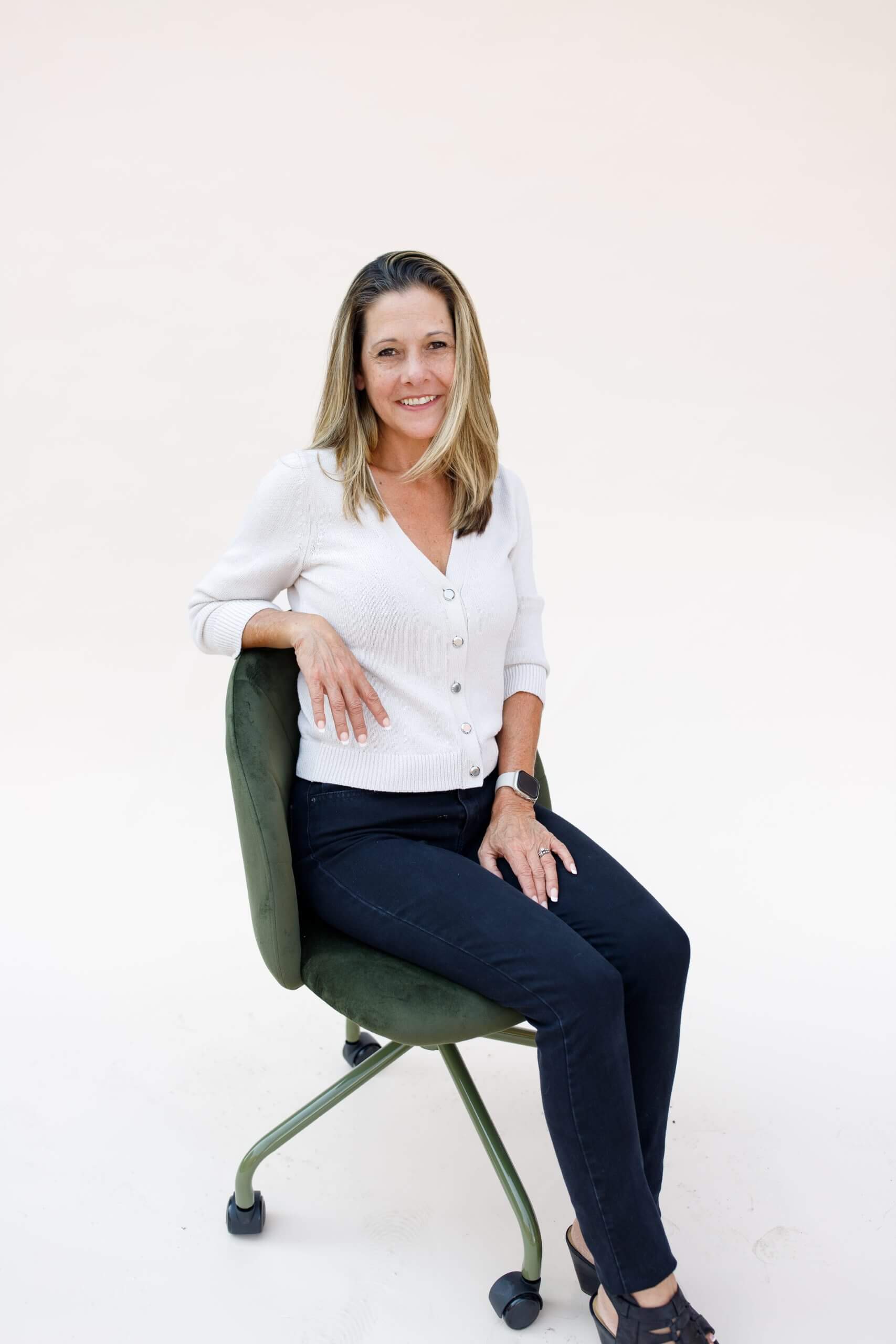 Woman sitting on a green office chair.